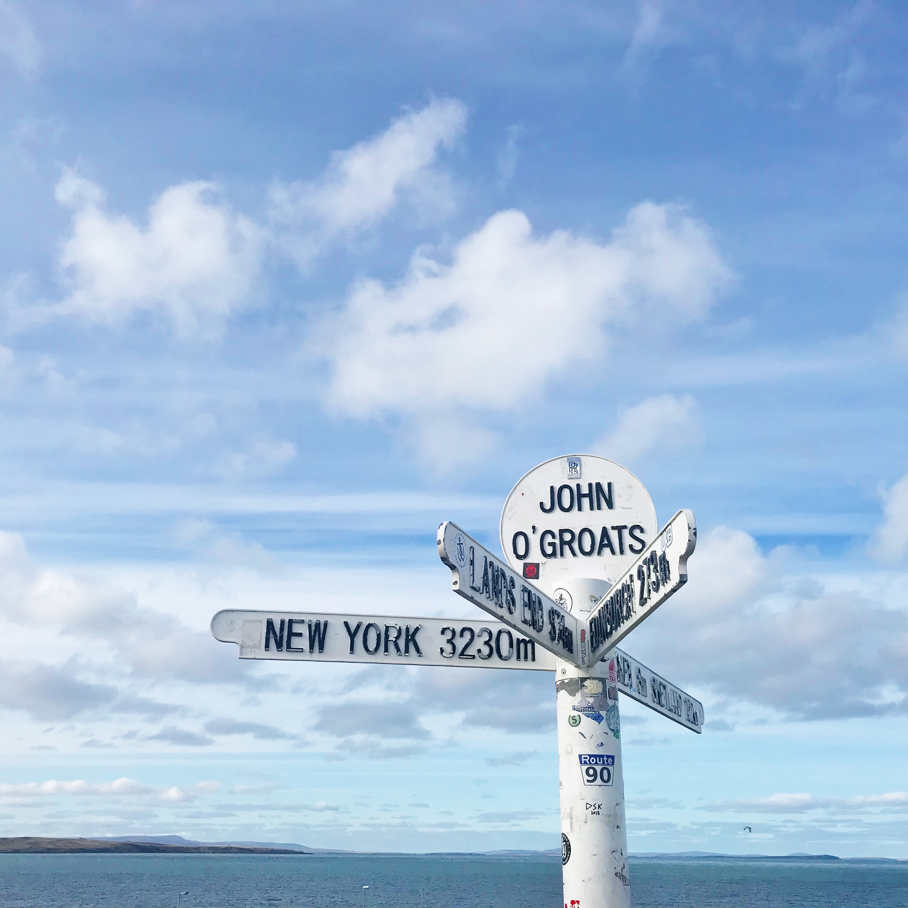 Picture of iconic sign at John O' Groats showing distances to Land's End, New York etc.