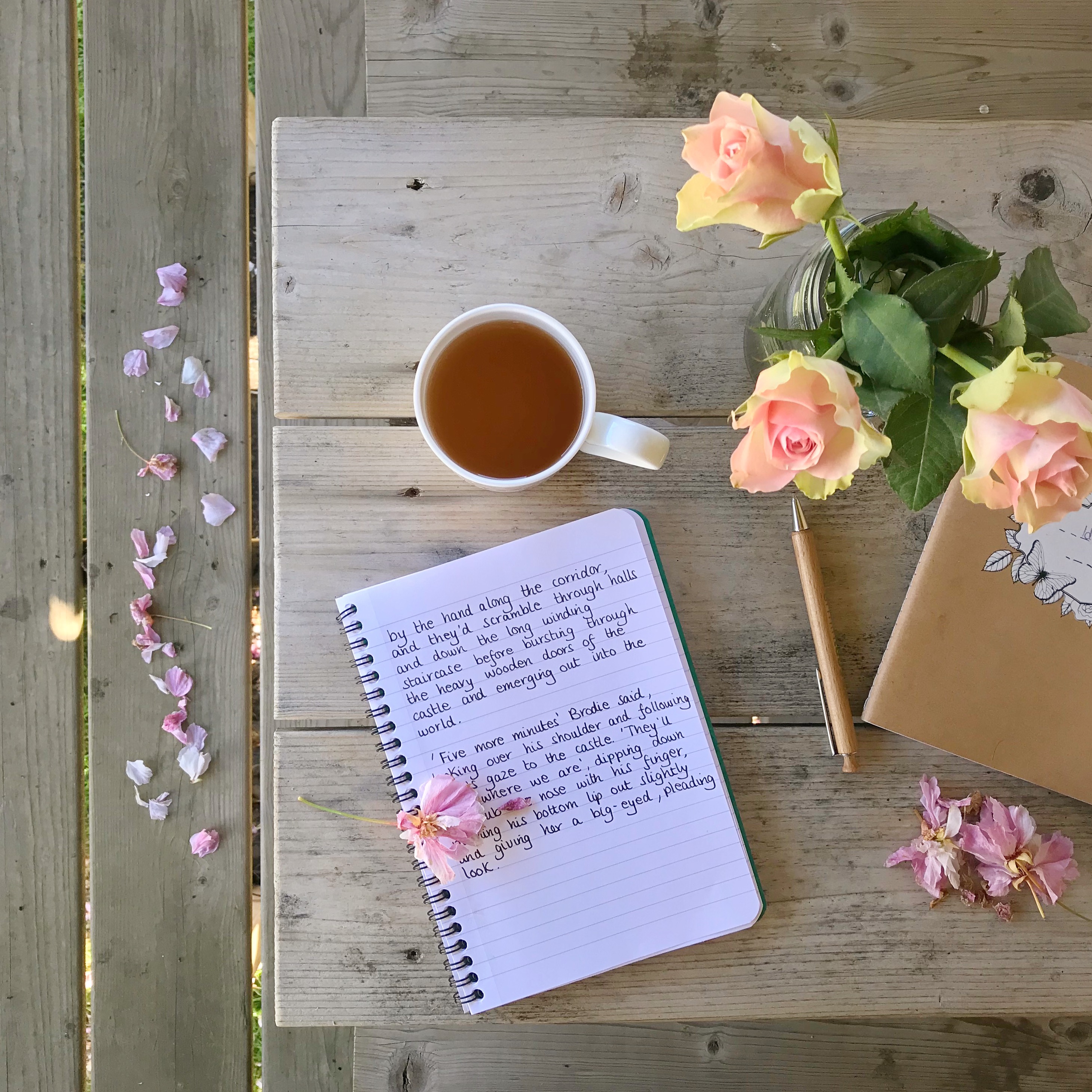 Picture of notebook and tea on table with flowers