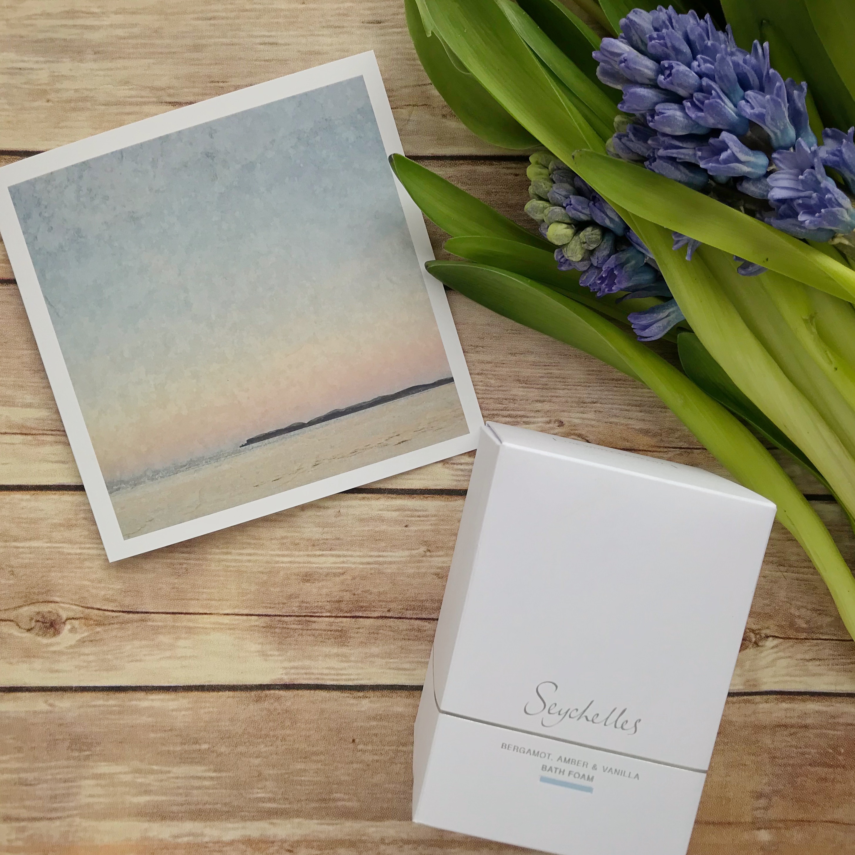 Flatlay photo of card, flowers and bath foam