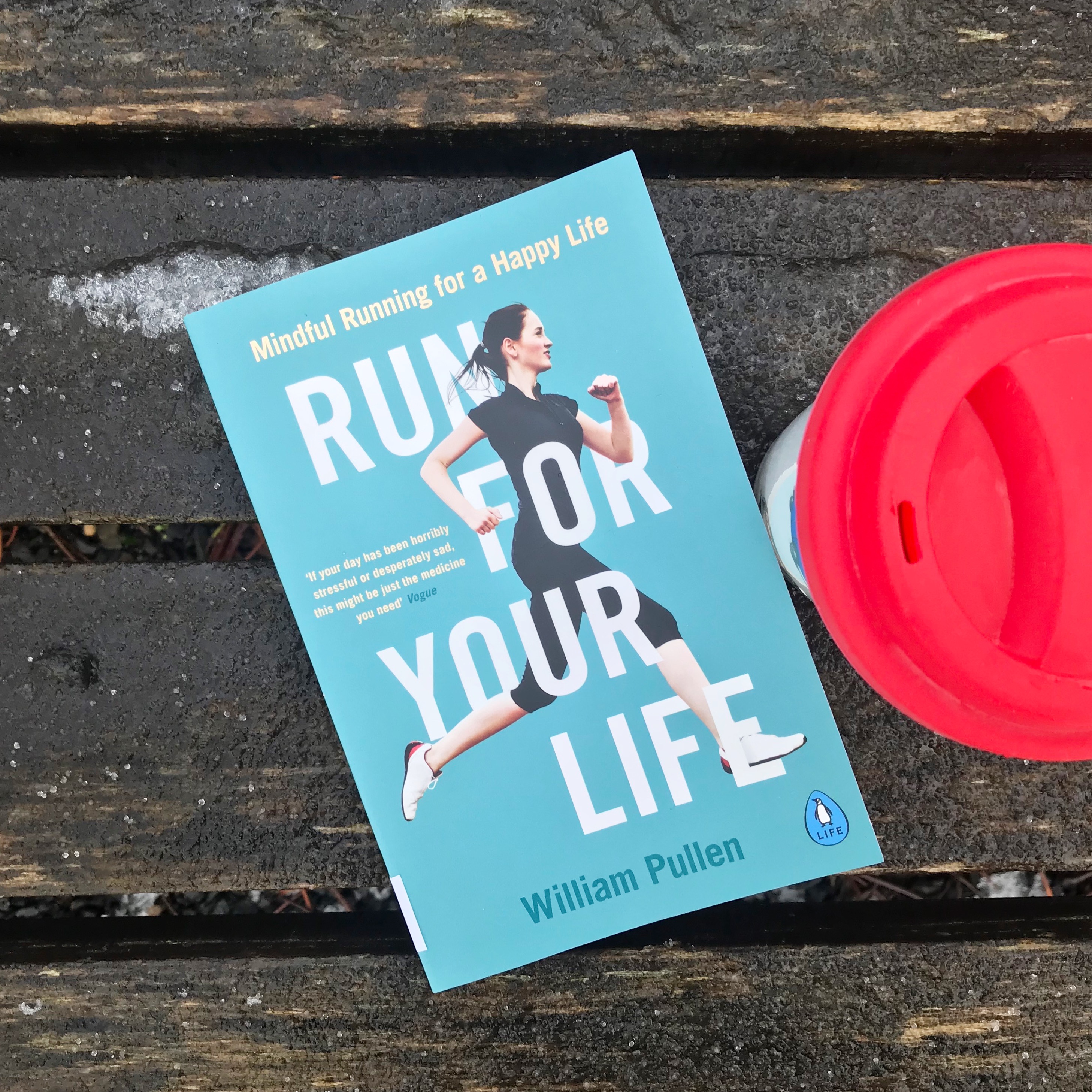Picture of 'Run for your Life' book on bench with travel mug.