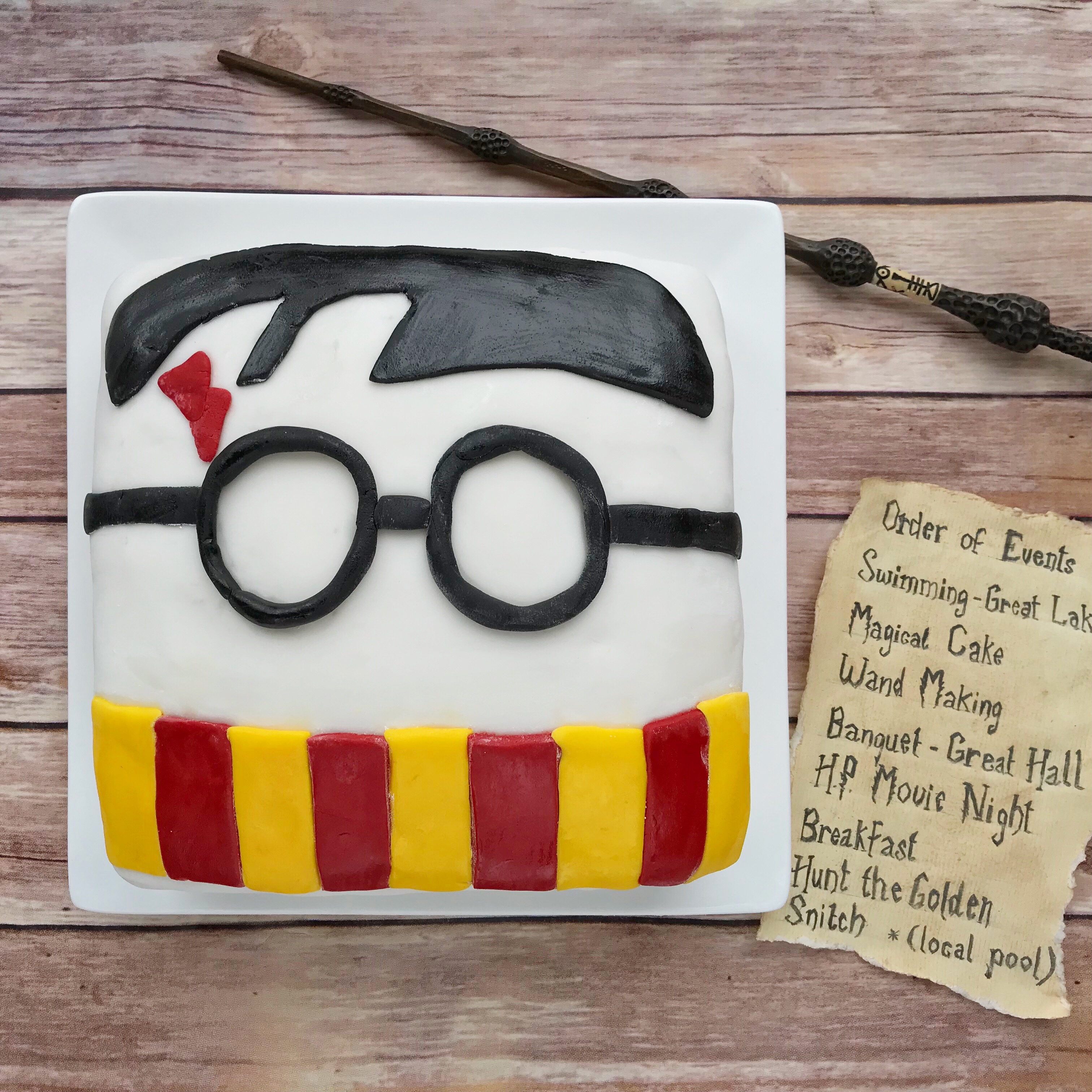 Picture of Harry Potter cake with wand and scroll on table
