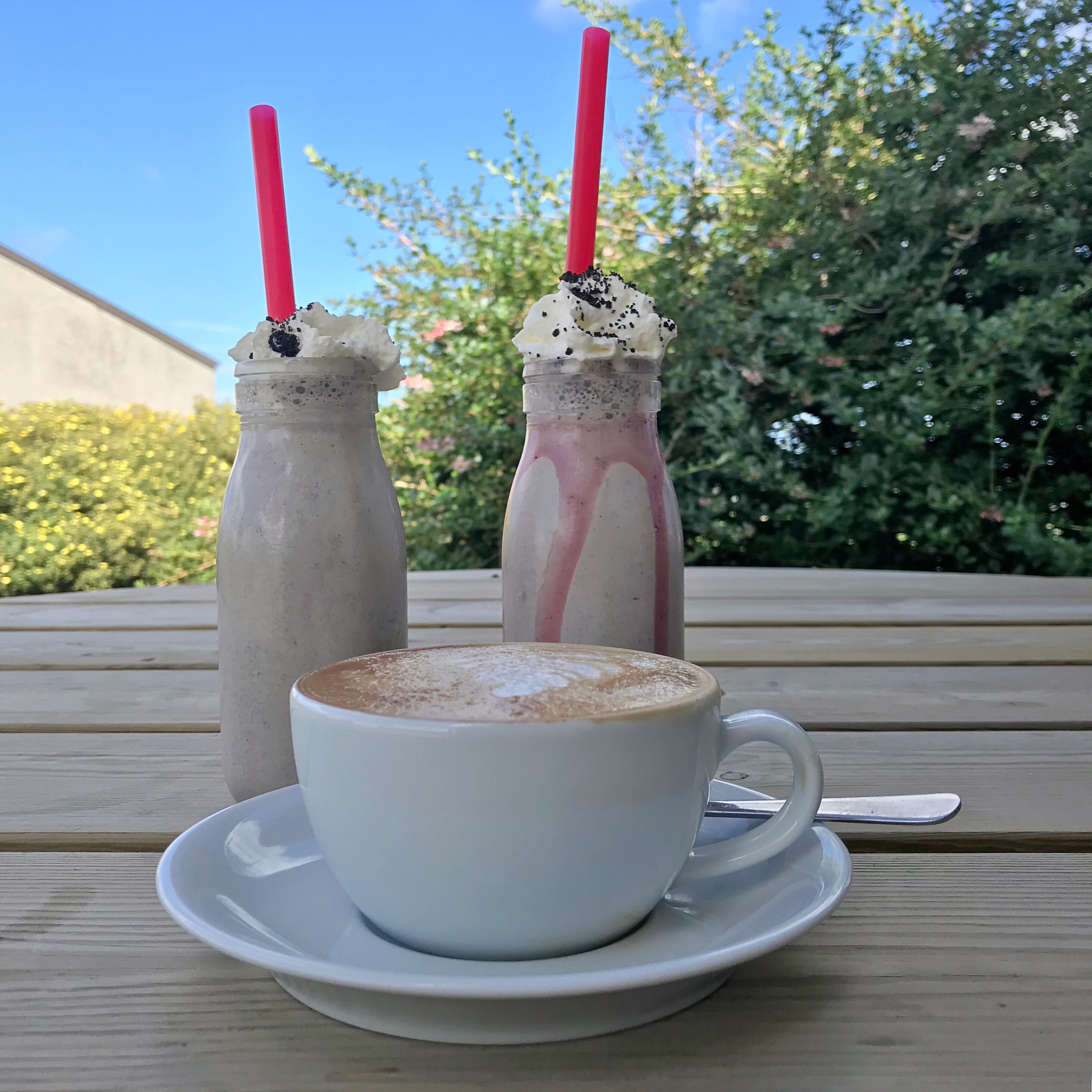 Picture of milkshakes and coffee outside on table