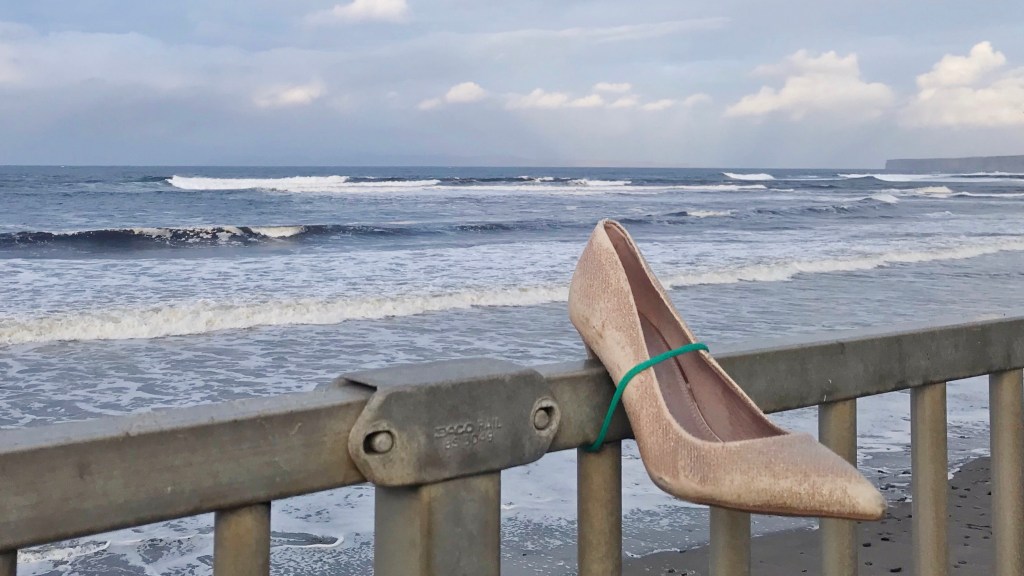 Photo of lone stiletto left on beach railing