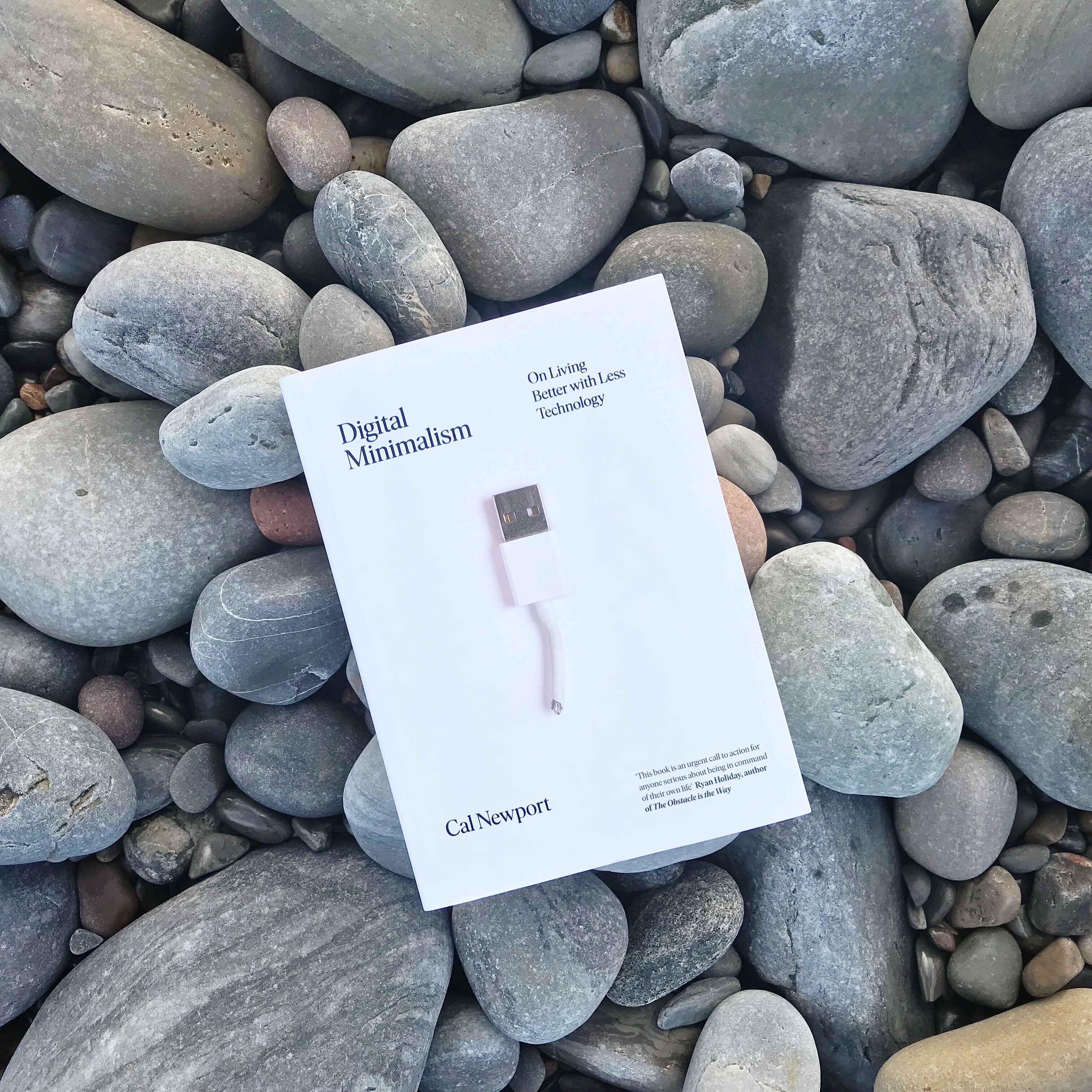 Digital Minimalism book by Cal Newport on pebbles