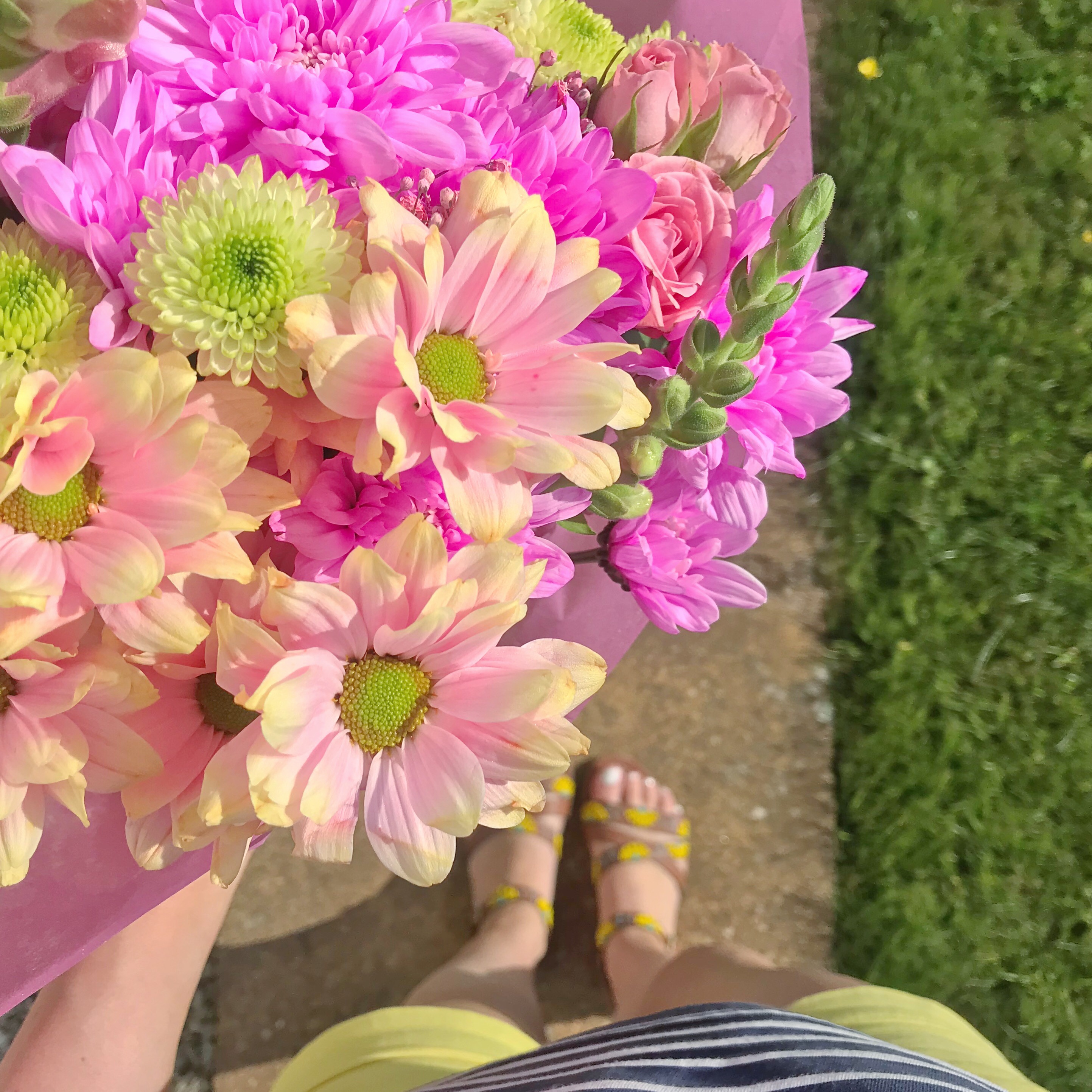 Photo of blogger in shorts holding brightly coloured flowers