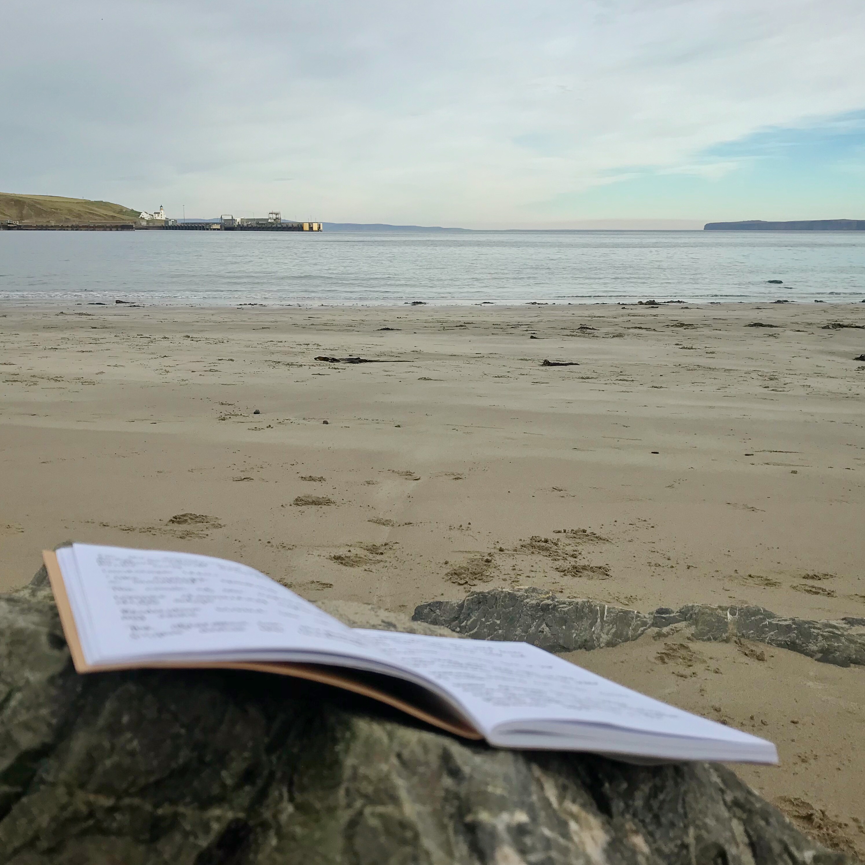 Photo of notepad in foreground and beach scene