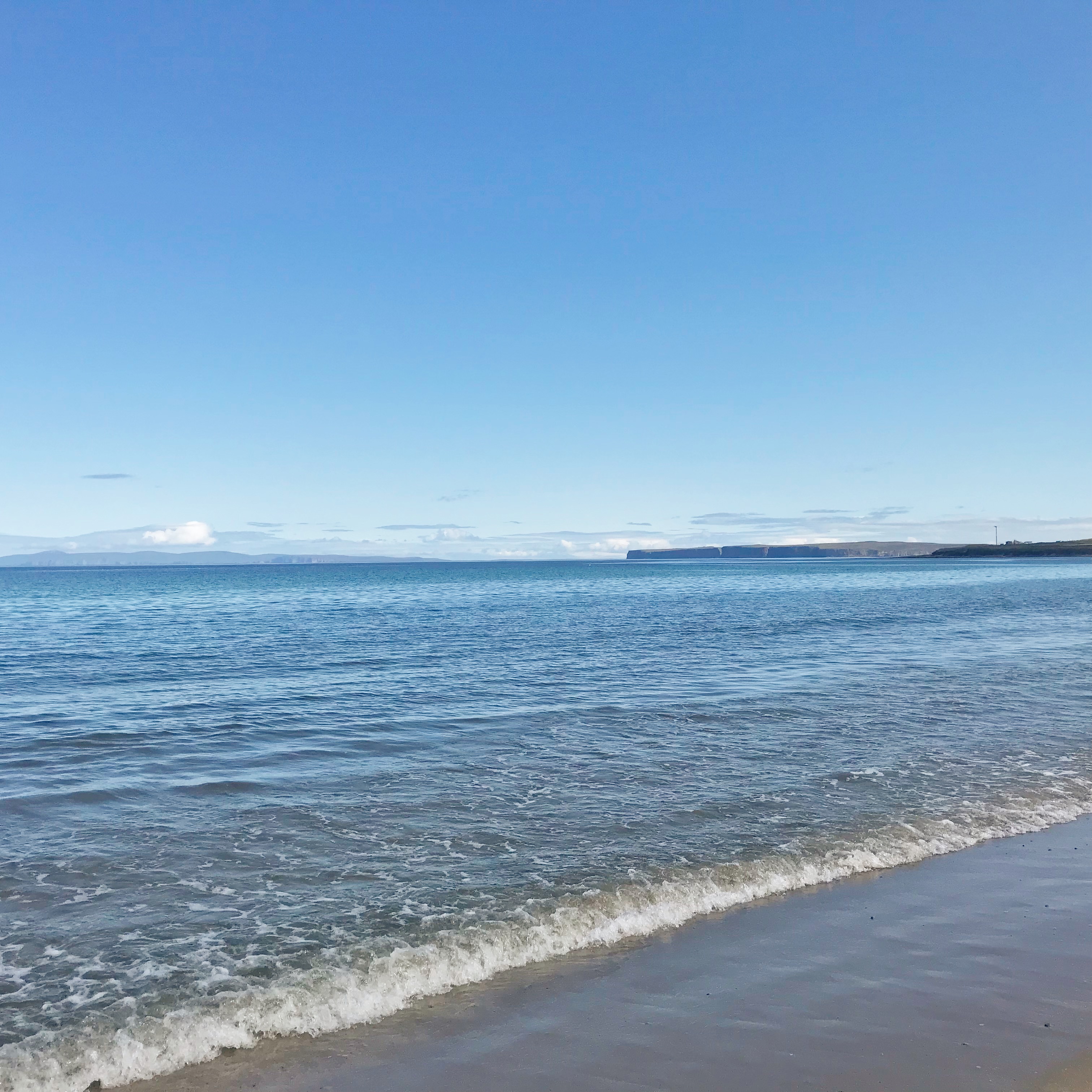 View of beach in Caithness, Scotland, with blue skies