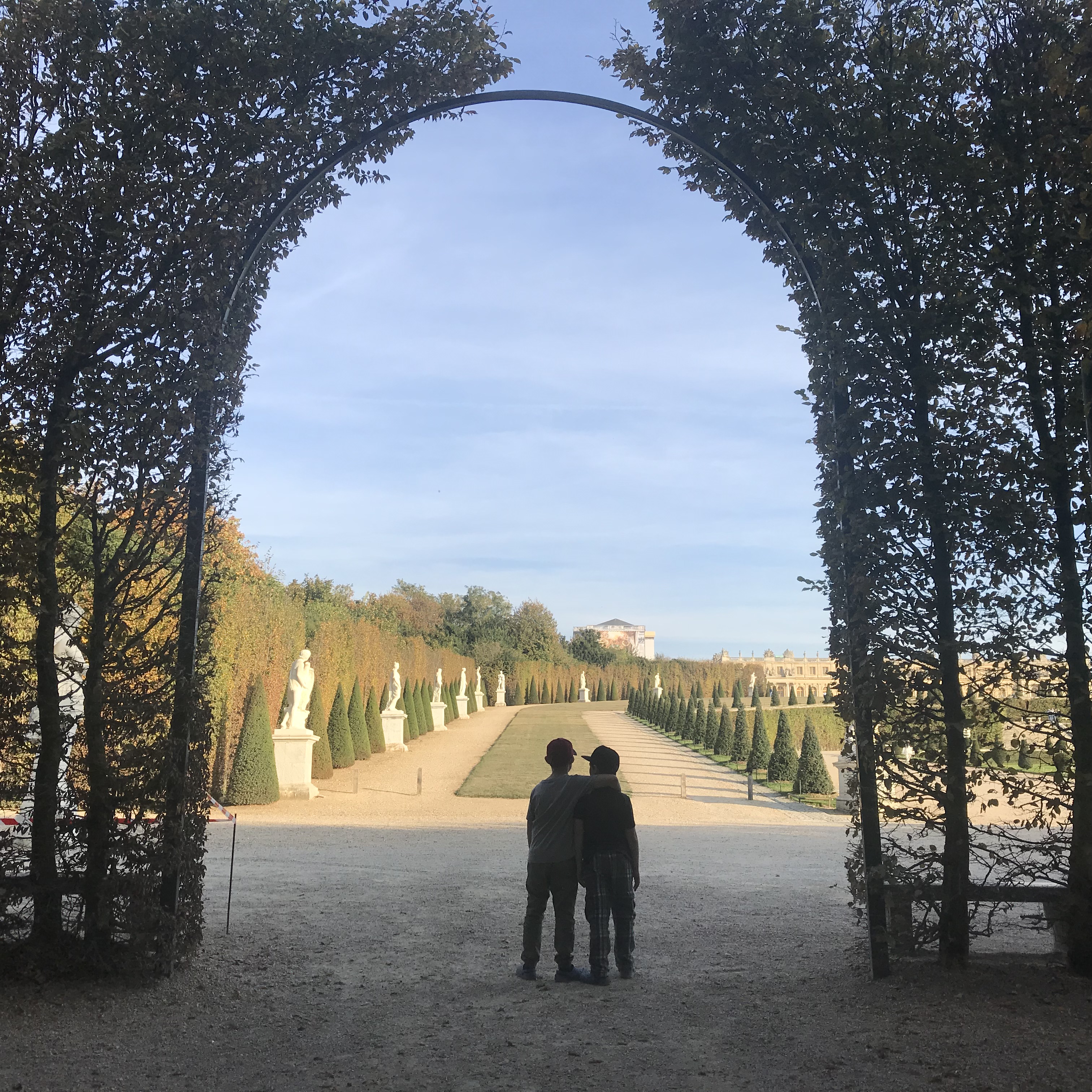 Picture of boys looking out of archway in the Palace of Versailles Gardens