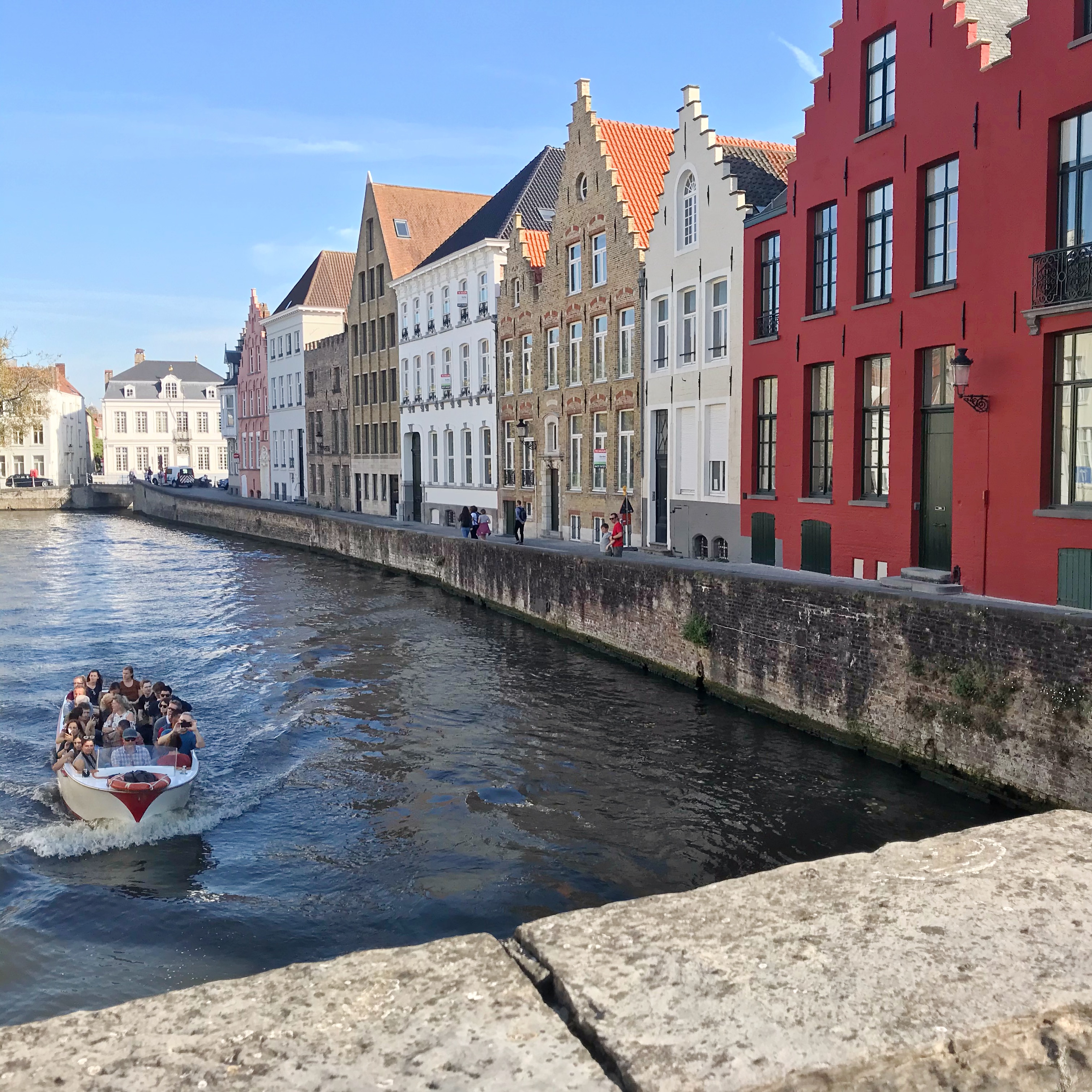 Bruges Scene with colourful houses and canal boat