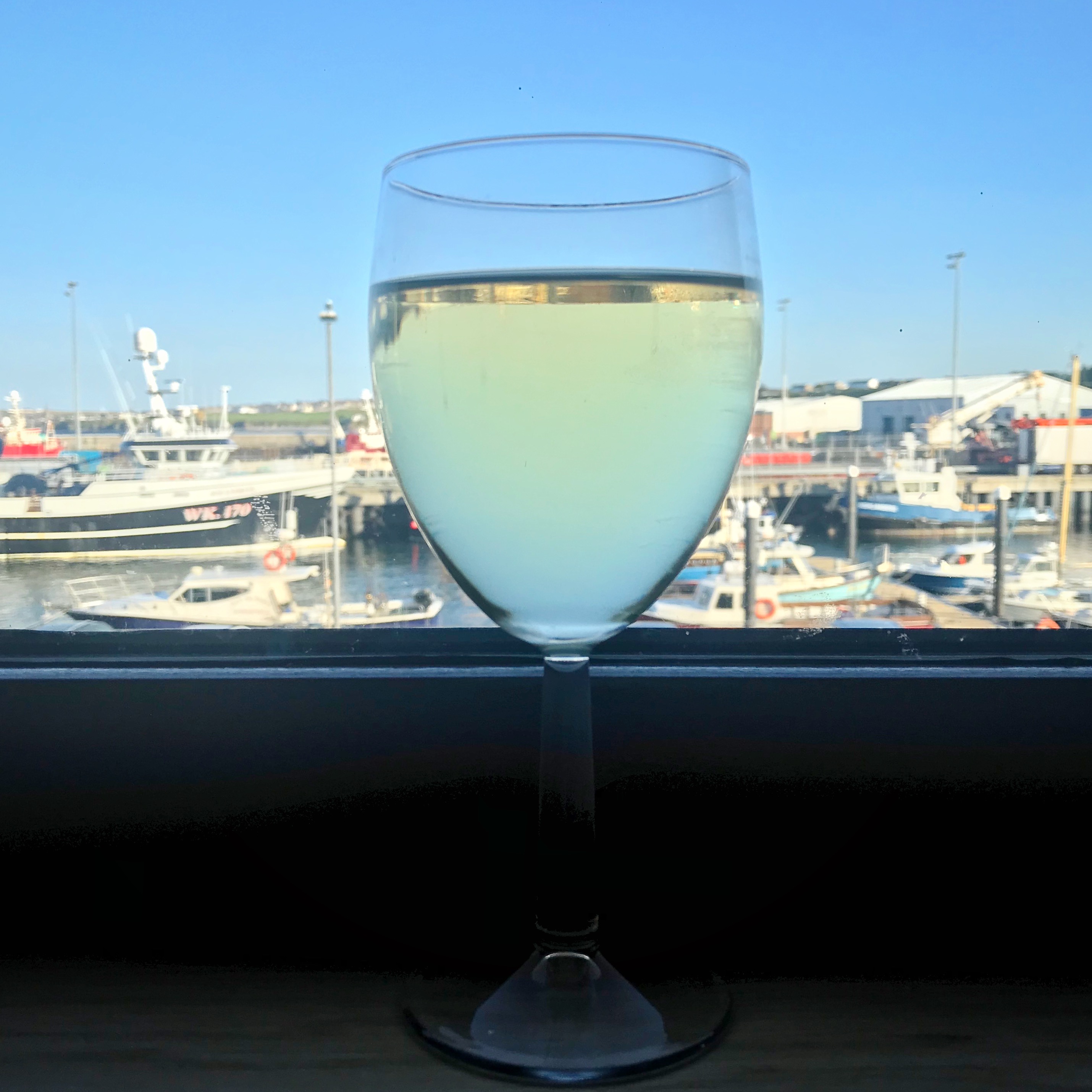 Picture of wine on windowsill with harbour view