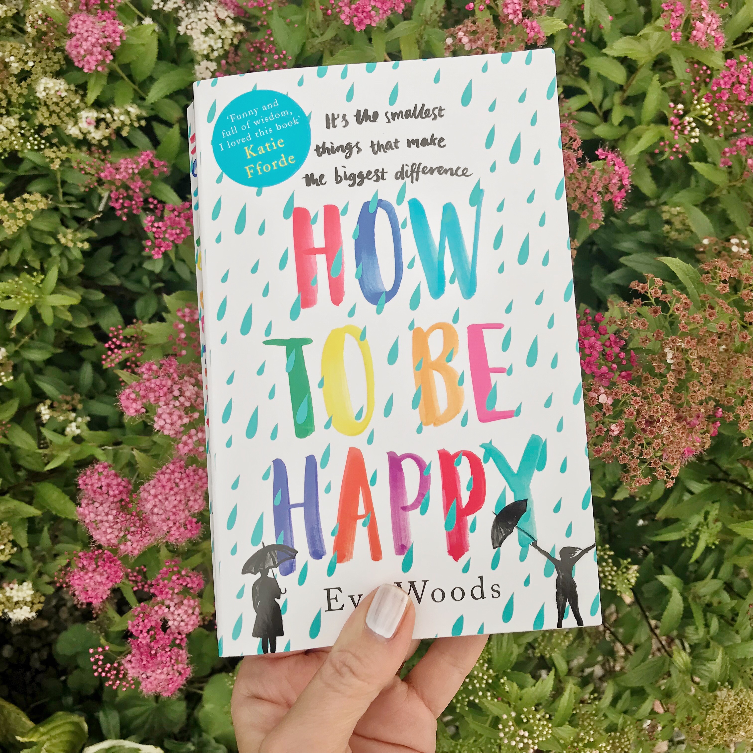 Picture of 'How to be Happy' book against flowers